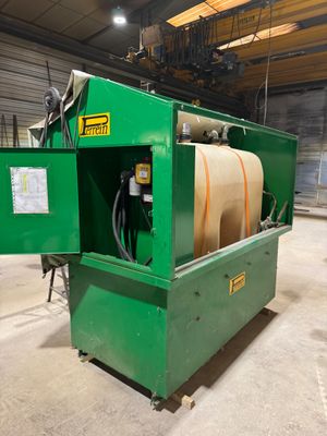 une machine verte dans un entrepôt, avec un tuyau à l'intérieur