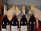 three bottles of red wine are lined up on a table