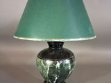 une lampe verte surmontée d'un abat-jour vert