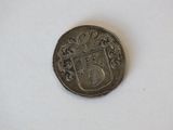 a silver coin with a coat of arms on it