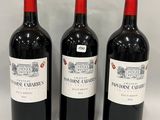 three bottles of wine are lined up on a white surface
