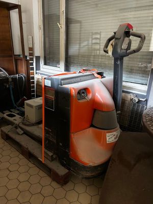 a large orange and black machine sitting on a pallet