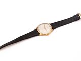 un gros plan d'une montre sur une surface blanche avec un fond blanc