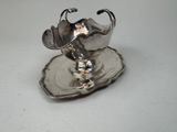 a silver plate with a silver flower on it