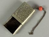 a silver case with a red bead on a chain