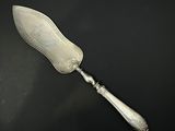 un couteau à beurre ancien plaqué argent posé sur une surface noire