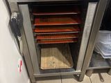 a silver oven with trays of food inside of it