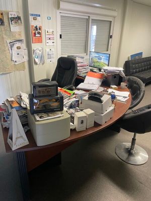 un bureau sur lequel s'entassent beaucoup d'objets