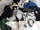 a pile of clothes that is on a bed