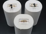 three rings are sitting in a white box on a black surface