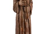 wooden statue of a man holding a book and a hat