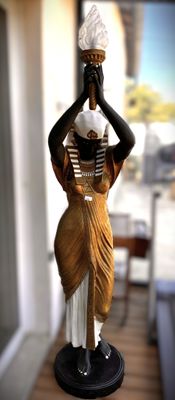 une statue représentant une femme tenant un pot sur la tête