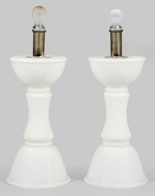 une paire de lampes de table blanches sur des socles, avec une ampoule au milieu