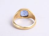 a close up of a gold ring with a blue stone in it