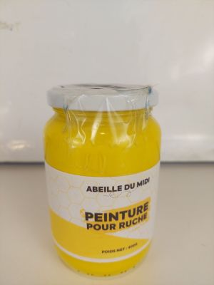 un pot de peinture jaune posé sur un plan de travail