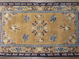 un tapis jaune avec une bordure bleue et des fleurs dessus