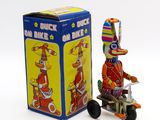 figurine représentant un clown sur un tricycle, à côté d'une boîte
