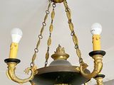 a gold chandelier with three lights hanging from the ceiling