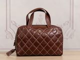 a brown handbag sitting on top of a wooden table