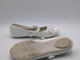 pair of white children ' s shoes on a white surface with a white background