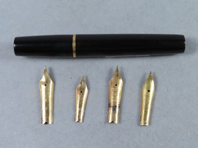 un gros plan d'un stylo-plume et de cinq autres stylos posés sur une table