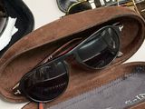 a pair of sunglasses in a case next to a pair of sunglasses