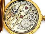 a close up of a pocket watch on a white surface