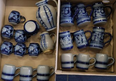 une boîte remplie de tasses à café et de mugs bleus et blancs