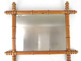 a mirror hanging on the wall with a wooden frame