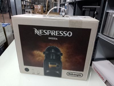 une boîte contenant une machine à café Nespresso Nesa posée sur une table