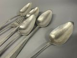 five spoons and two spoons sitting on a table