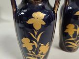 two blue vases with gold designs on them