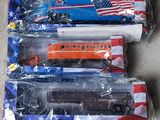 cinq camions miniatures dans des sacs en plastique posés par terre