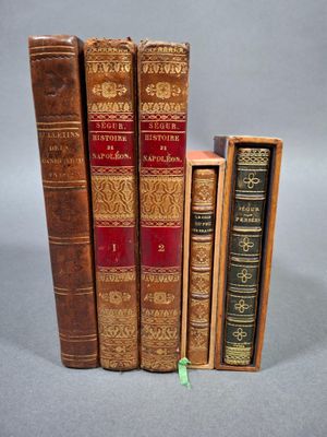 trois vieux livres posés l'un sur l'autre sur une table