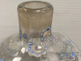 a glass vase with blue designs on it on a table