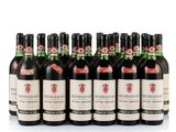 six bottles of wine are lined up in a row on a white surface
