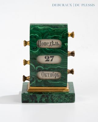 a green and gold clock on a white surface