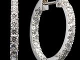 une paire de boucles d'oreilles créoles en diamant sur fond noir