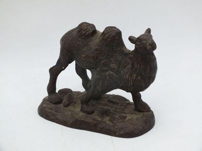 statue d'un chameau posé sur un rocher, sur fond blanc