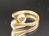gros plan d'une bague en or sur une surface noire