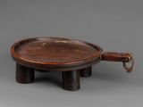 an old wooden tray with a handle on a gray surface