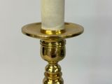 a close up of a gold candle holder with a white candle on it