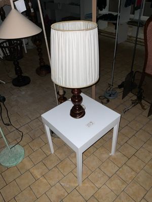 une table blanche sur laquelle est posée une lampe, dans un salon