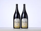 two bottles of wine sitting on top of a table next to each other