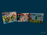 trois boîtes de Lego posées sur une surface bleue