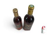 two bottles of wine sitting next to each other on a white surface