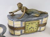a statue of a woman laying on top of a clock