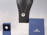 trois colliers et une bague exposés sur une table