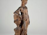 an antique statue of a woman holding a basket of flowers