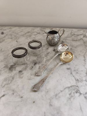 une table en marbre sur laquelle sont posés de l'argenterie et une cuillère en argent